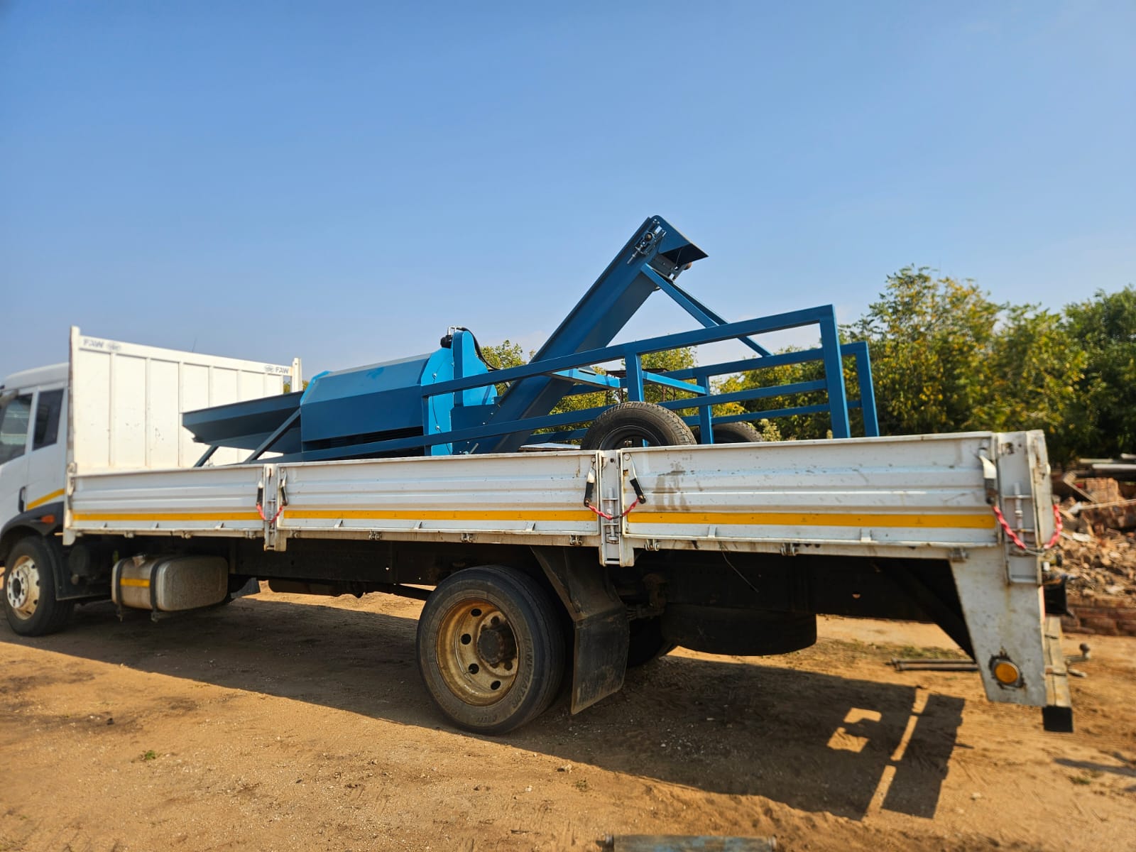 Blue SMJ orchard sweeper loaded on a truck for delivery