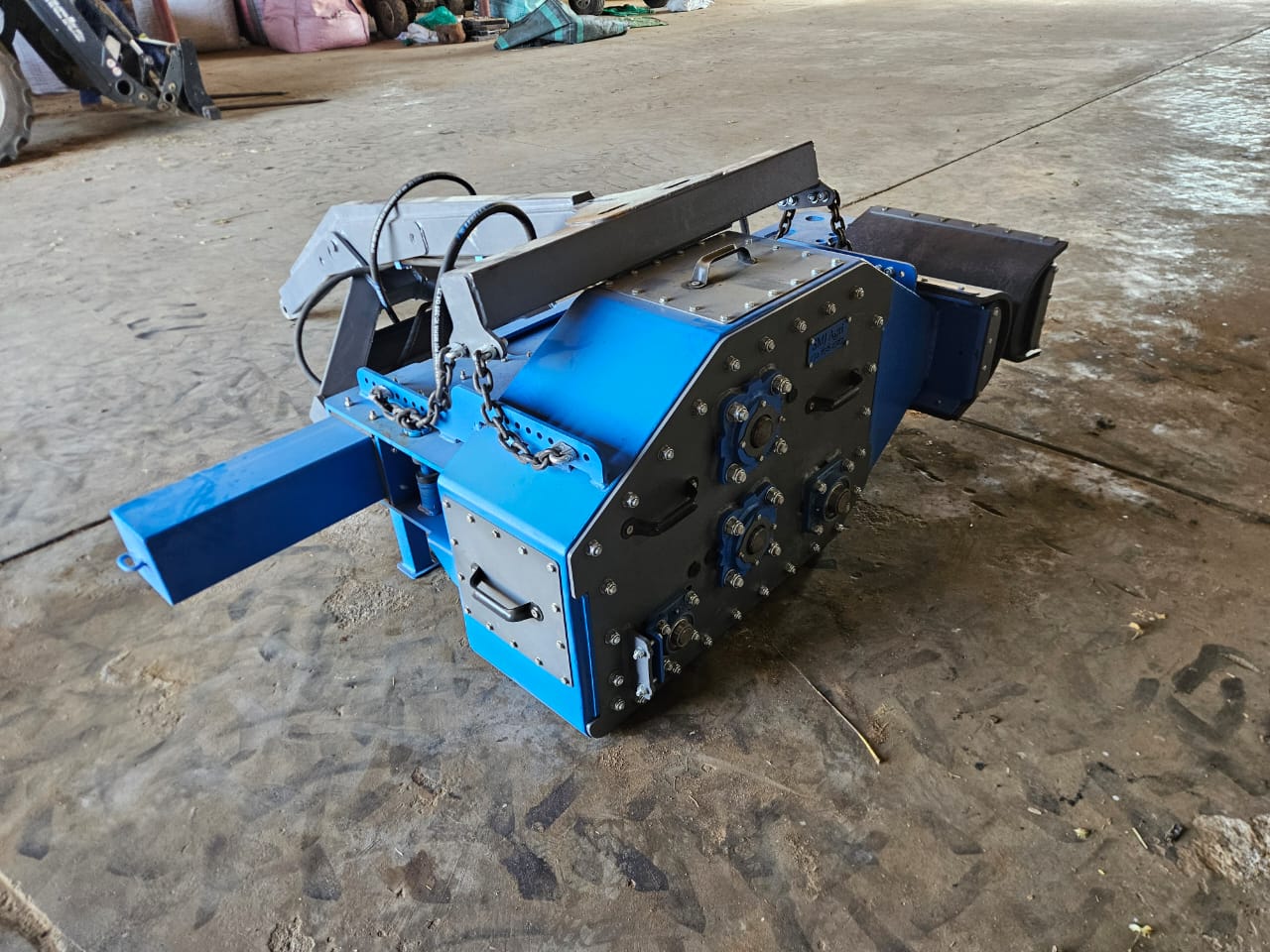 Heavy-duty gearbox and drive unit with circular hubs and hydraulic lines on a workshop floor