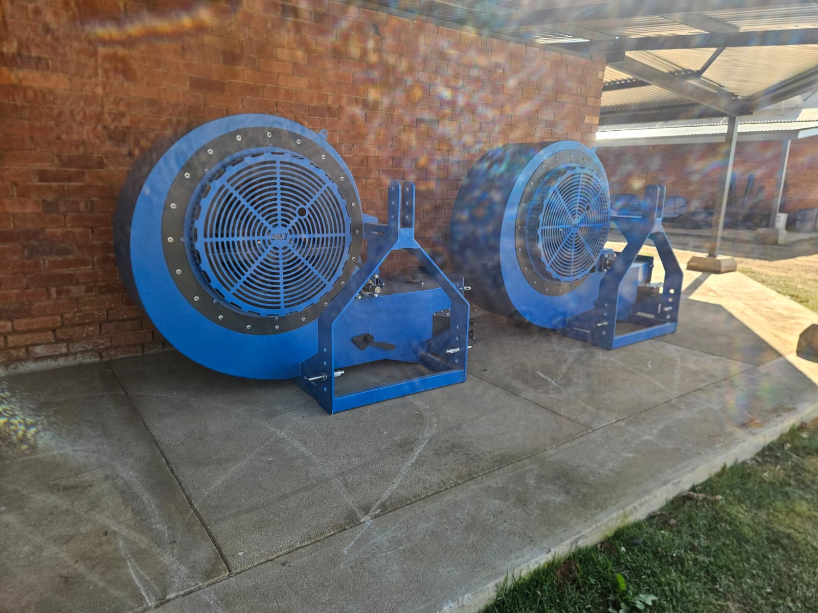 Two SMJ orchard blowers standing against a brick wall