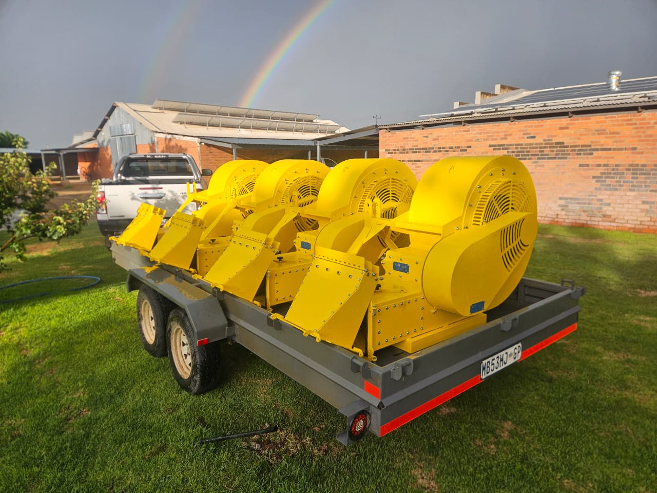 Orchard blowers loaded on a trailer under a rainbow